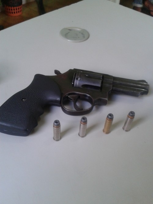 Revólver e munições apreendidas pelos policiais.